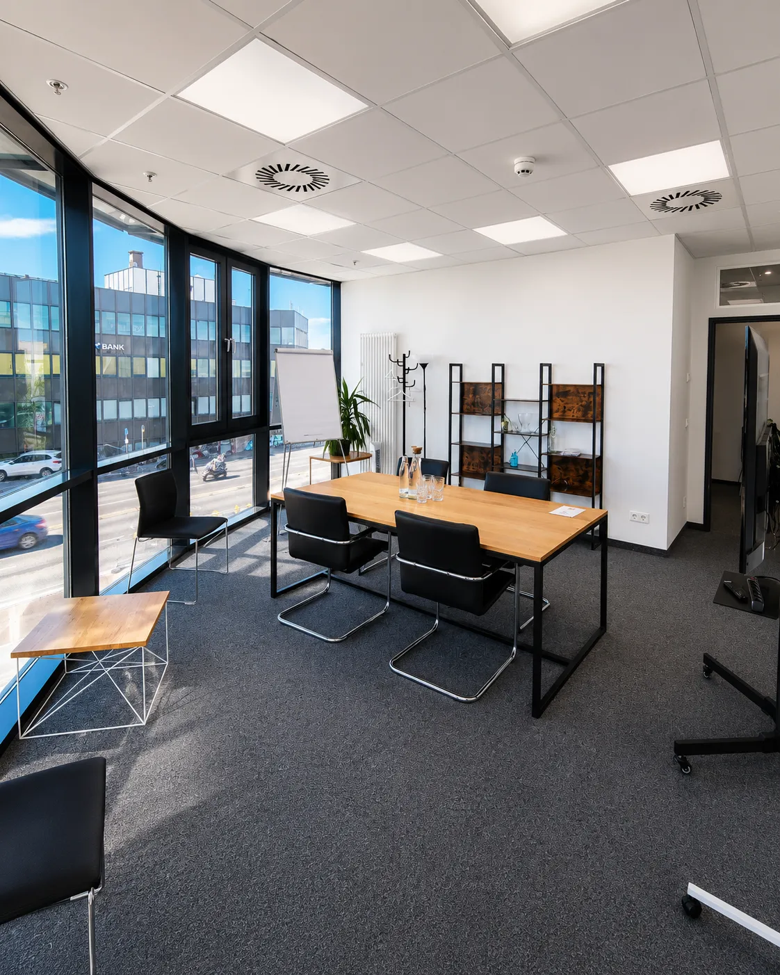 Blick in den Konferenzraum mit Tageslicht, Sideboard und Sitzgruppe an der Eckfensterfront